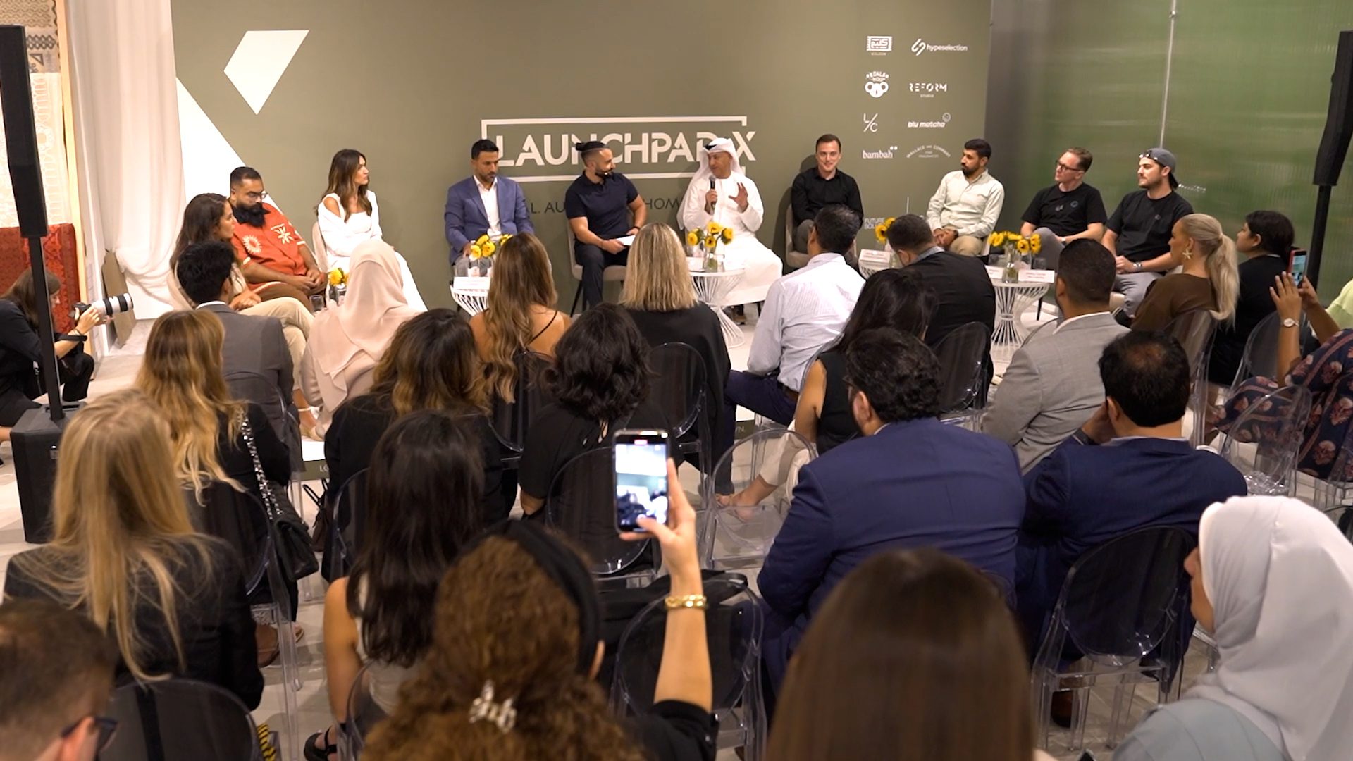 A panel discussion in front of a seated audience at the Launchpad X store opening.