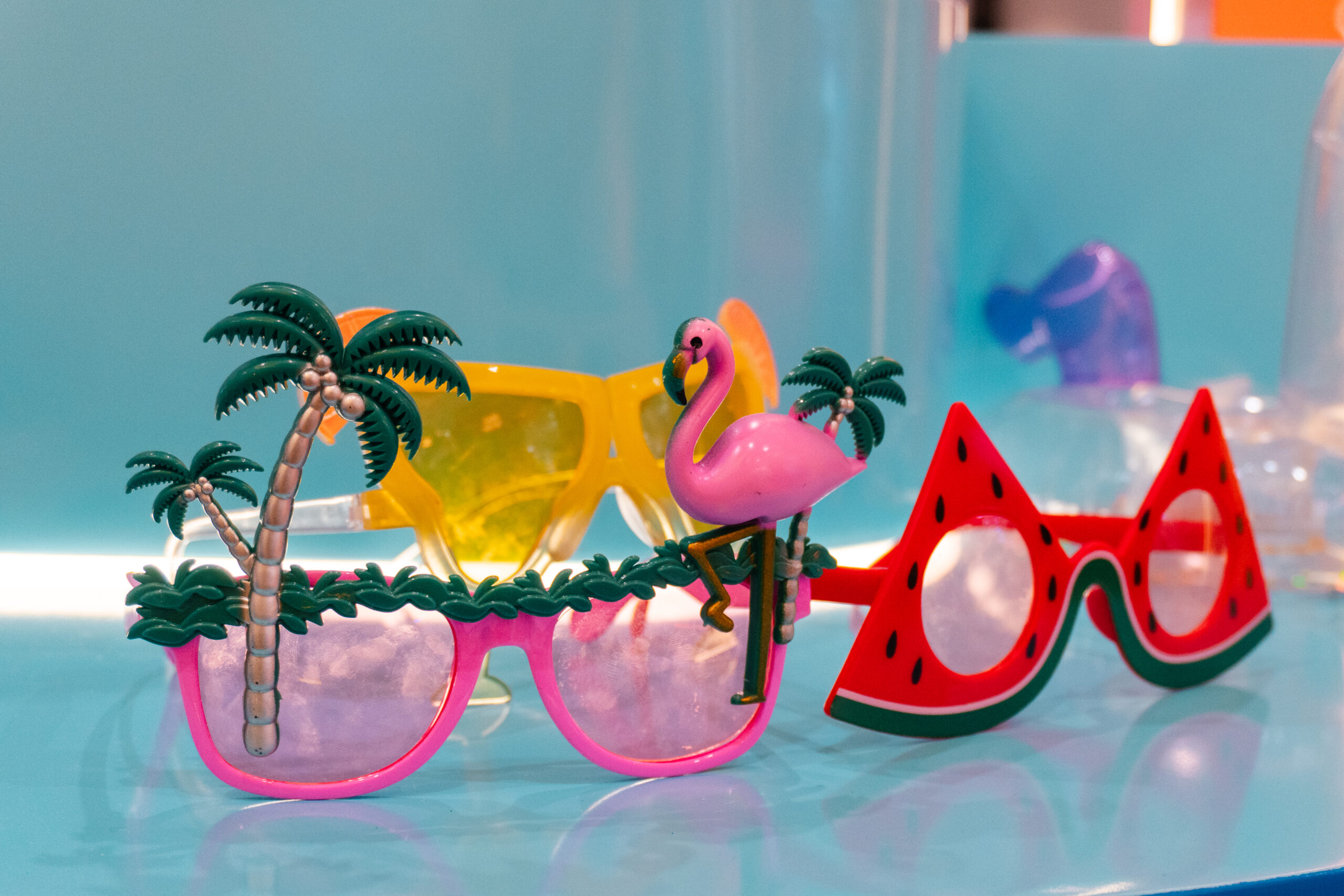 Novelty summer sunglasses on display — palm tree, flamingo and watermelon frames