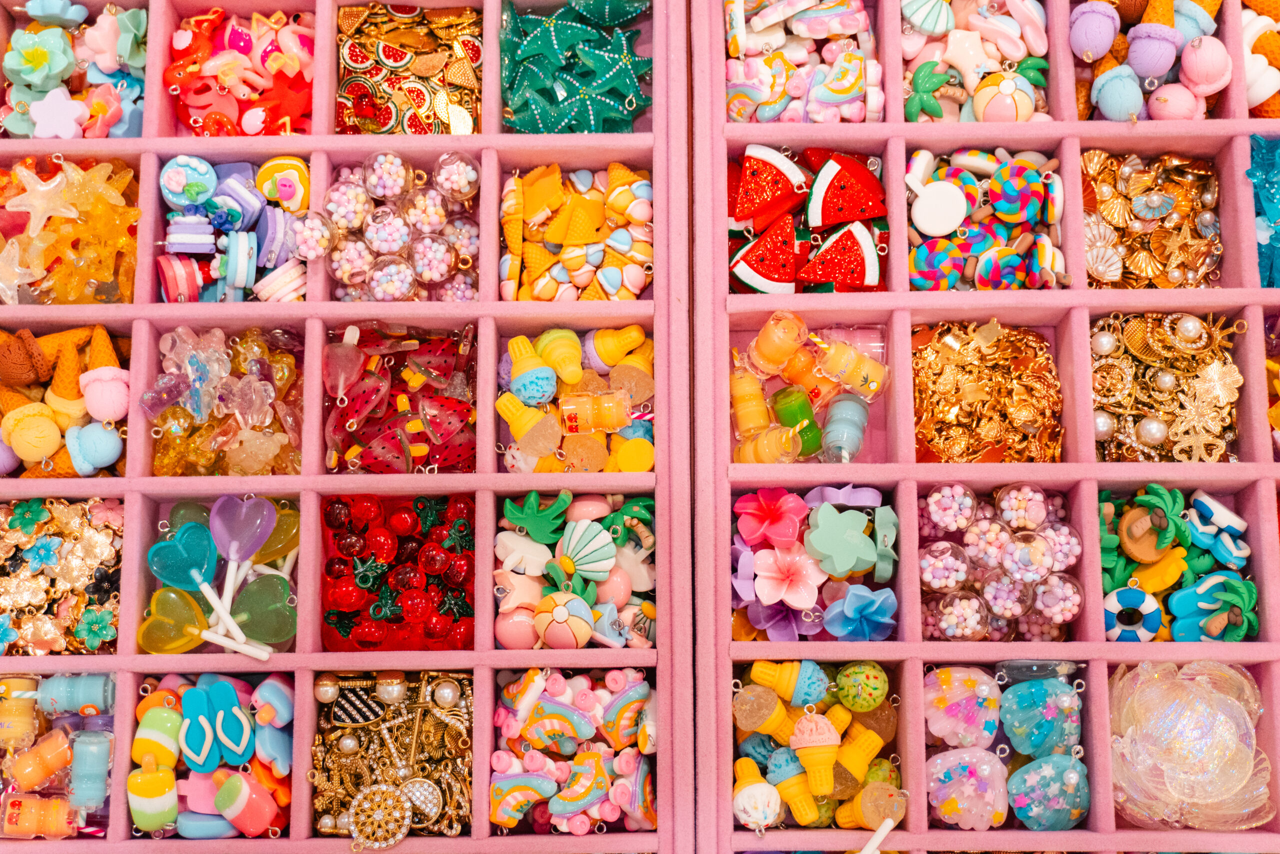 Trays of beads and charms sorted by colour for visitors making their own bag charms